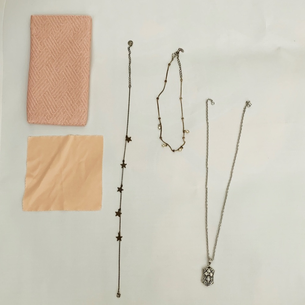3 necklaces and a sunglasses holder and cleaner
